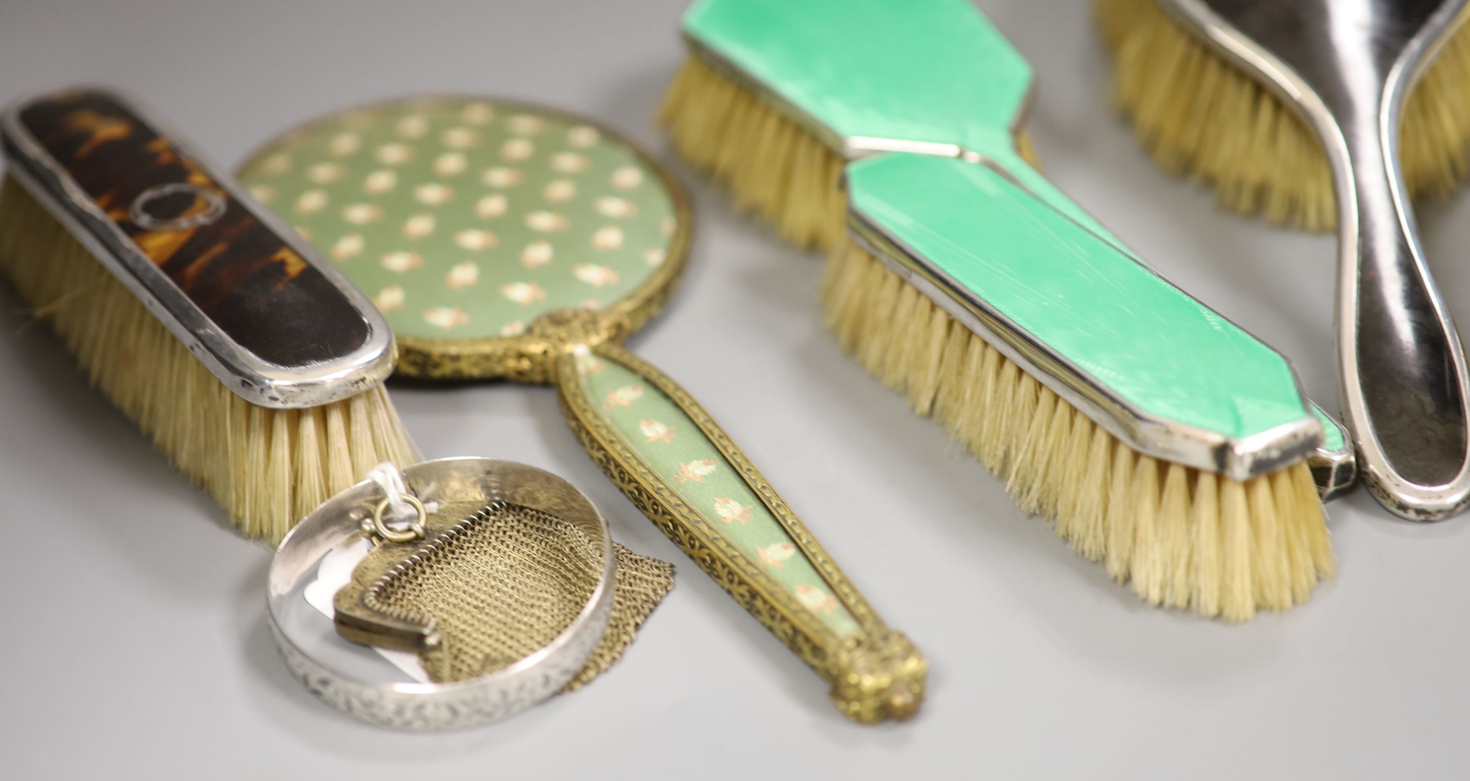A guilloche enamel and silver-mounted three-piece brush and comb set, three other silver-mounted brushes and five other items,